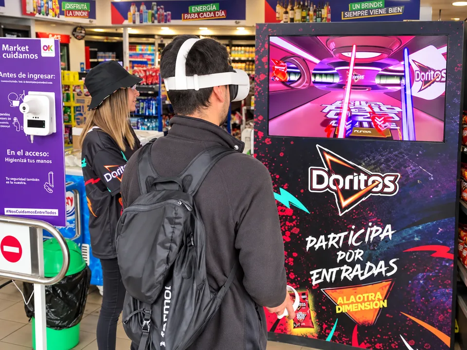 Portada retocada: participante con visor VR frente al juego personalizado de Doritos